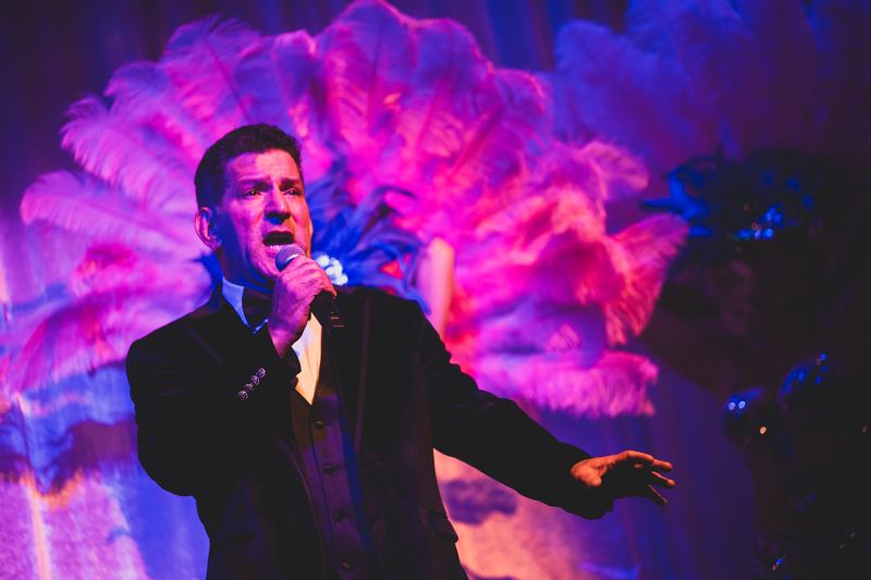 Belting it out against pink plumes