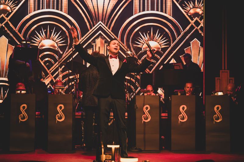 Arms wide in front of the big band